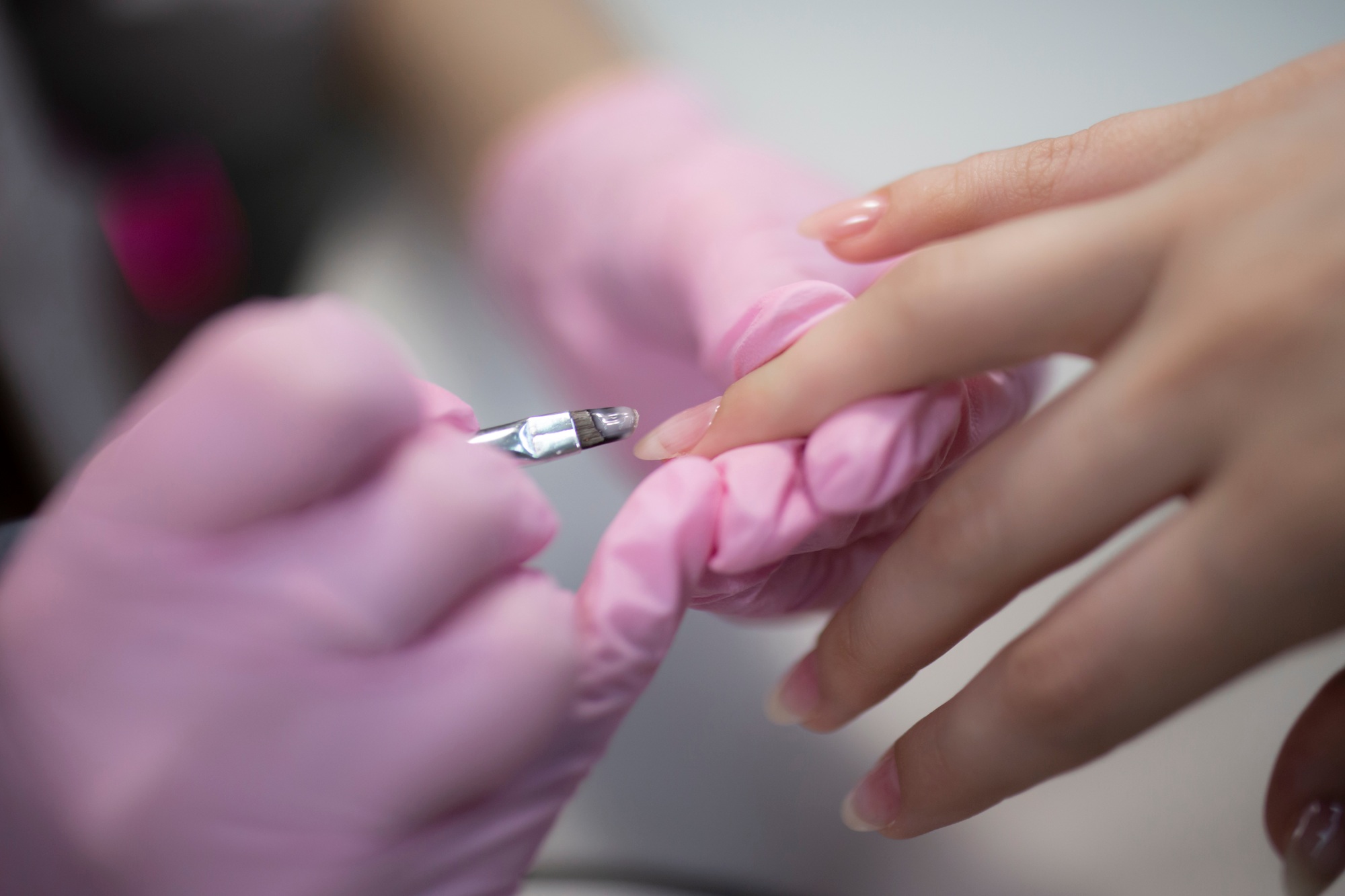 a manicure master in process of nail treatment in beauty salon